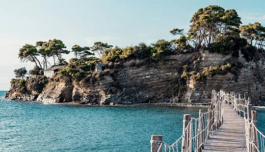 Wood bridge over turquoise waters leading to a tropical island (certified professional career coach)