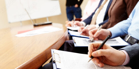 Multiple people writing on paper (CPCC certification)